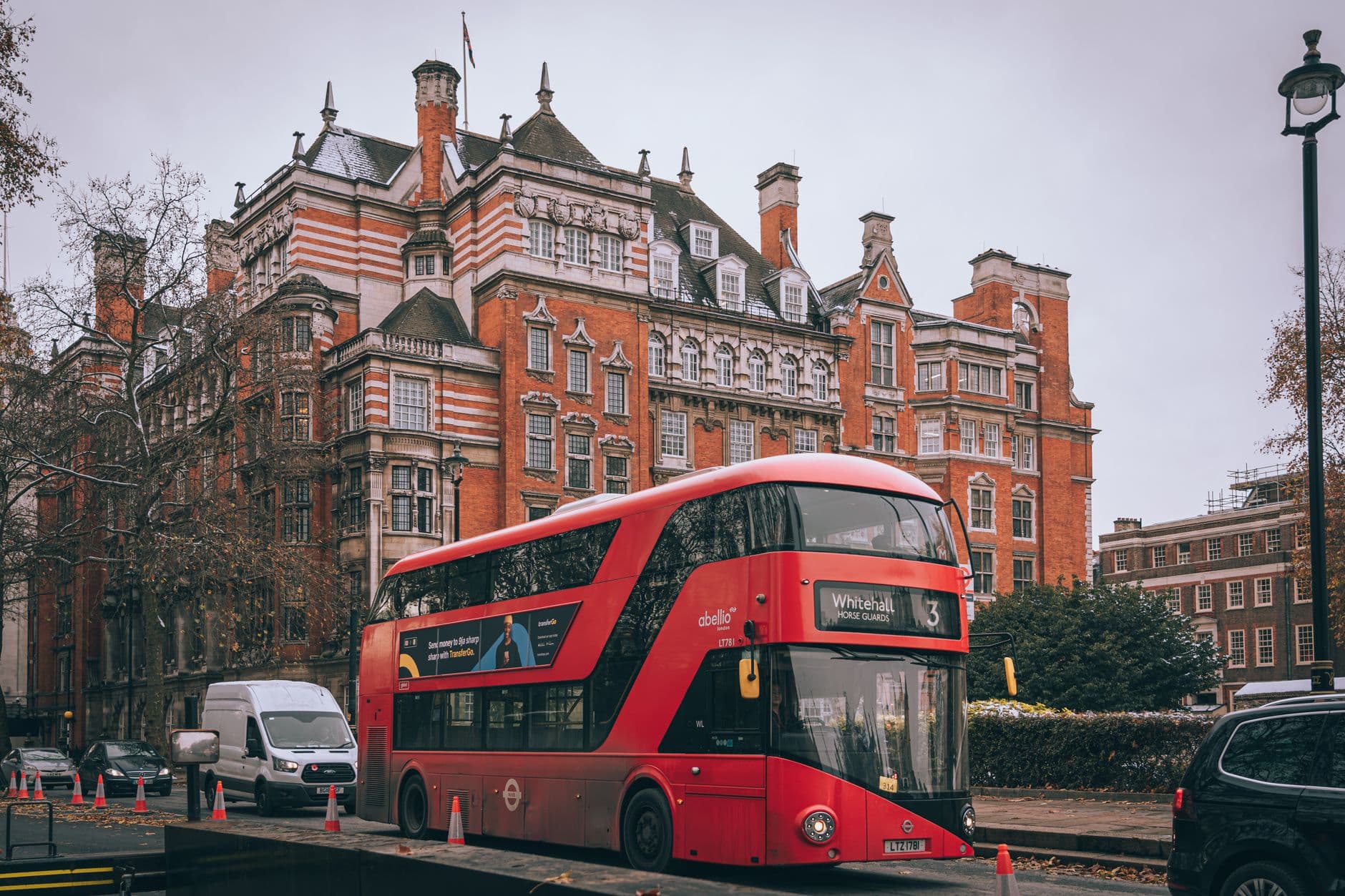 Red double-decker bus on a London street with classic architecture. Iconic British scene.